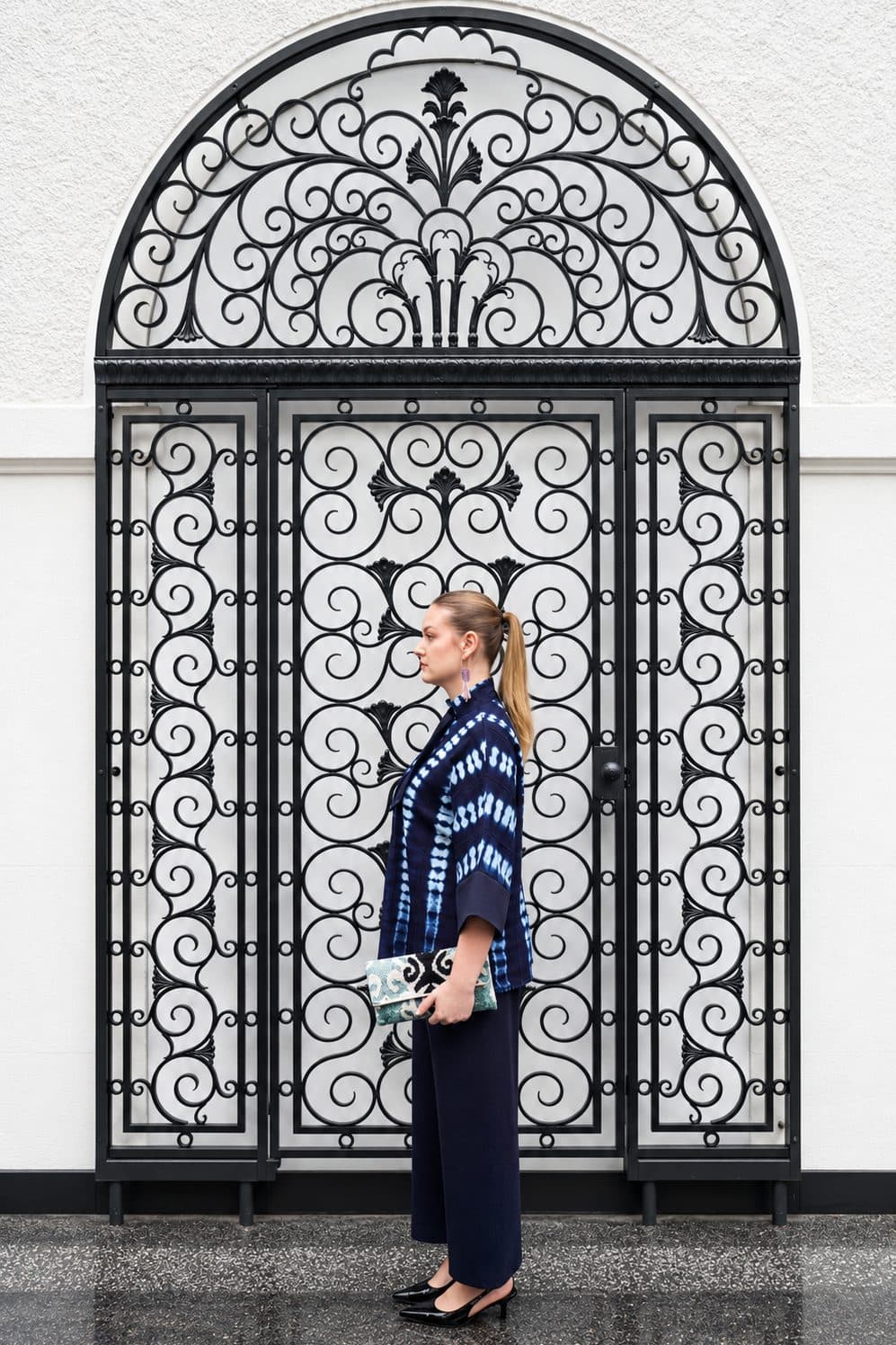 La Veste kimono Adire portée devant une grille ouvragée